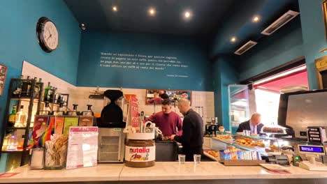 clientes y baristas en una cafetería de milán