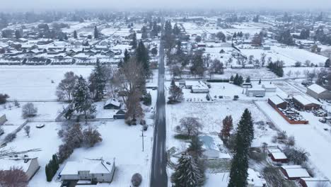 aerial view looking down a long bare road in rural america with snow covering the ground