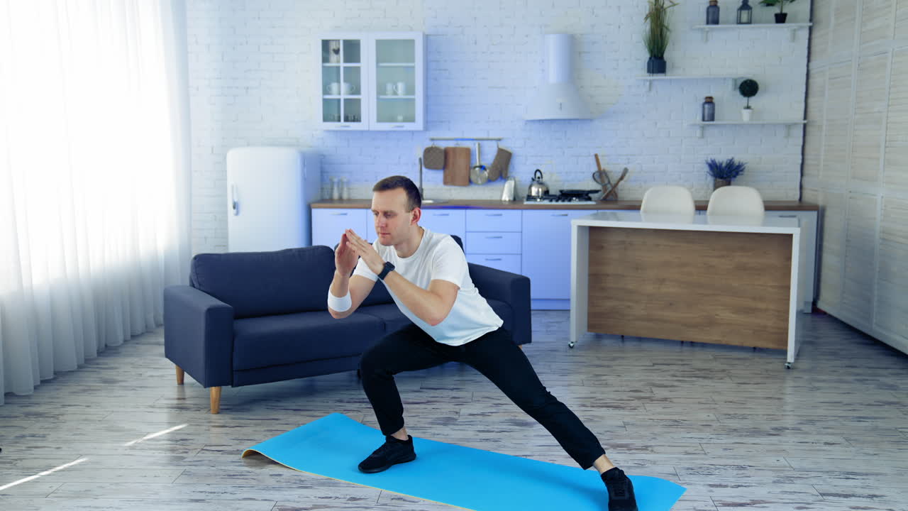 Man on fitness mat at home. Strong athletic fit man doing exercises at home