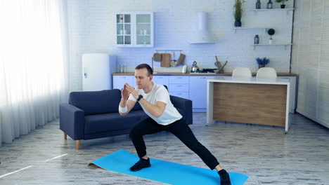 man on fitness mat at home. strong athletic fit man doing exercises at home