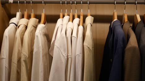 close-up of shirts hanging on wooden hangers in a closet