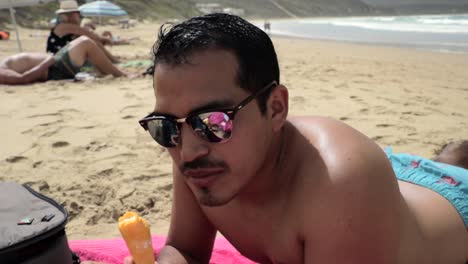 Hombre-Hispano-Comiendo-Un-Cono-De-Helado-En-La-Playa