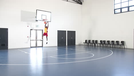 basketball player practicing dribbling on indoor court, focused and determined