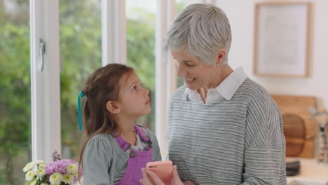 cute little girl showing grandmother how to use smartphone teaching granny modern technology intelligent child helping grandma with mobile phone at home