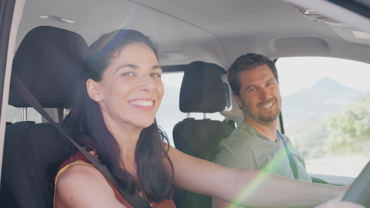 retrato de una pareja adulta sentada y conduciendo un coche de alquiler en las vacaciones de verano