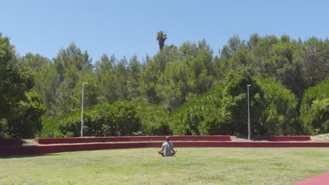 a person meditating in a lotus position in a grass field