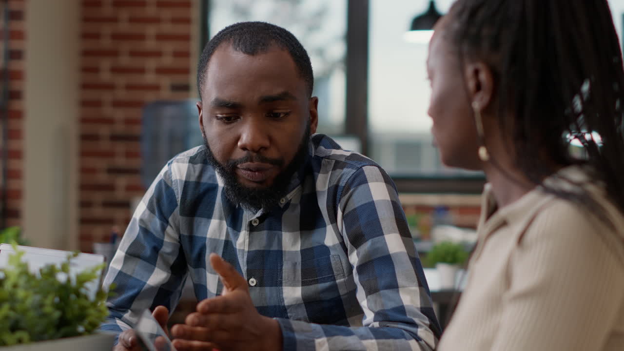 Team of african american people using sales statistics to create briefing presentation