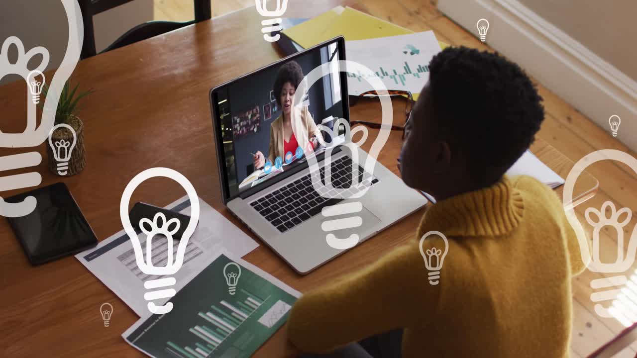 Animation of floating bulbs over african american woman having video call on laptop