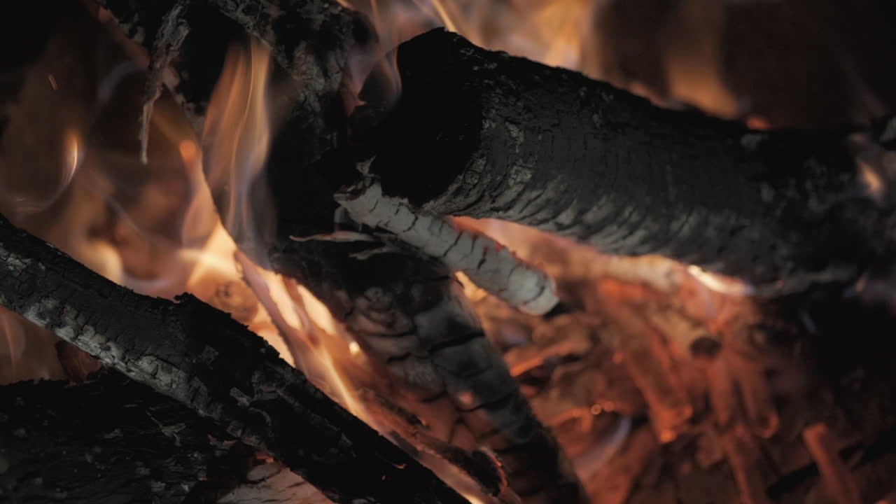 Crackling bonfire flames in slow motion, showcasing warmth and calm outdoor vibes