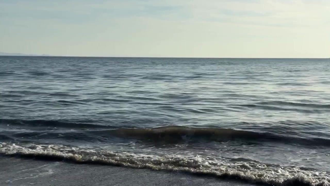 Onde pacifiche dell'oceano che si infrangono dolcemente su una riva sabbiosa