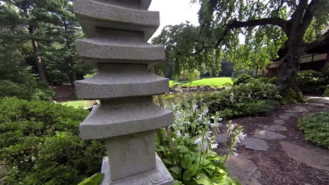 Steadicam-shot-moving-through-Japanese-garden-past-stone-pagoda-and-weeping-cherry-tree-to-view-of-exterior-of-house