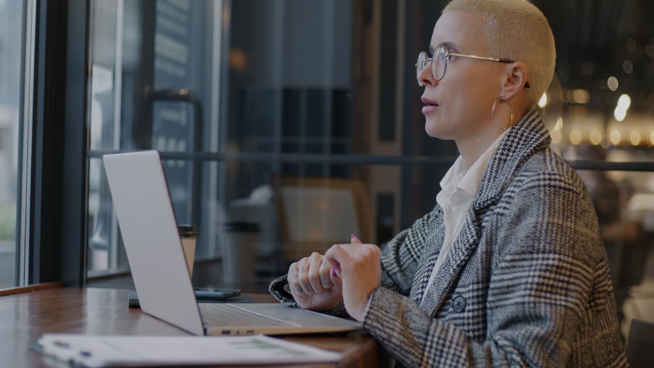 Woman Working on Laptop in a Cafe