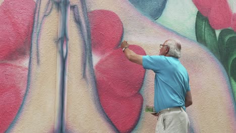 Street-Artist-doing-some-repairs-to-his-work