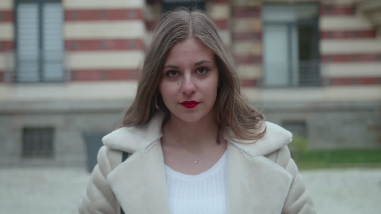 아름 다운 젊은 금발 소녀 카메라를 향해 걷고 그것에 미소