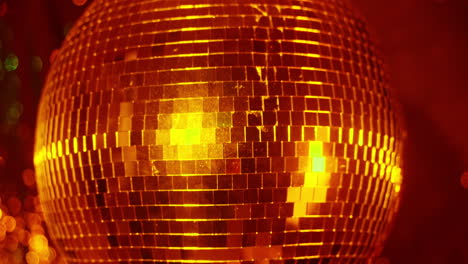 a spinning gold mirror ball in night club