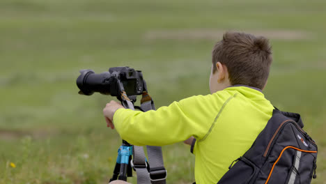 Young-boy,-photographer-setting-up-his-tripod-for-wildlife-video-production