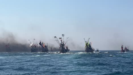 bug number of fishing boats in indian ocean during patik laut festival in muncar, banyuwangi, jawa, indonesia covered in smoke exhaust