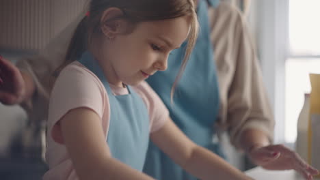la niña está aprendiendo a cocinar pastel o pan casero la madre y la hija están cocinando juntos en la cocina de la casa