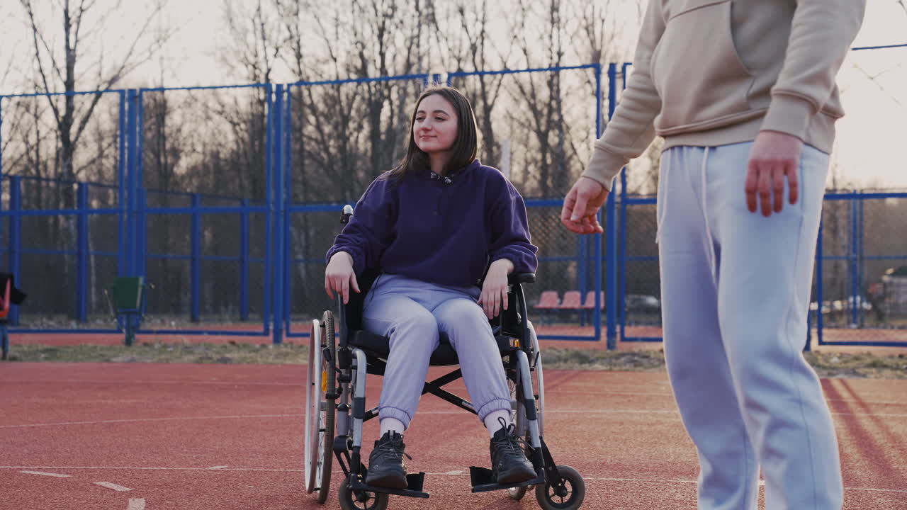 남자 친구와 농구를 하고 농구 골대에 공을 던지는 젊은 장애 여성