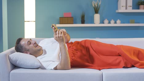 Man texting on the phone in bed.