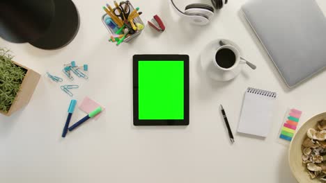 a finger touching a tablet with a green screen