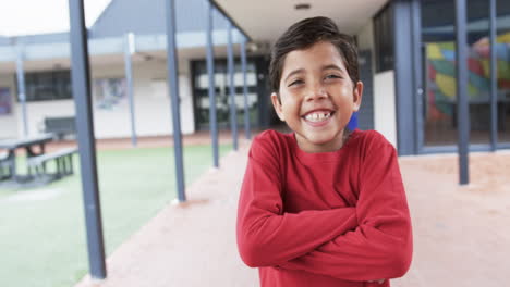 in a school courtyard, a young biracial boy smiles broadly