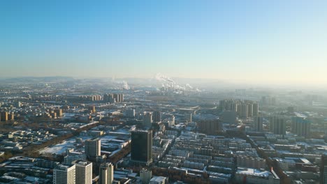 Perspectiva-Aérea-En-Un-Día-De-Invierno-Durante-La-Encantadora-Puesta-De-Sol-En-La-Ciudad-De-Zibo,-Provincia-De-Shandong,-China,-Que-Revela-Una-Escena-Cautivadora-Con-La-Silueta-De-Las-Plantas-De-Energía-Al-Fondo