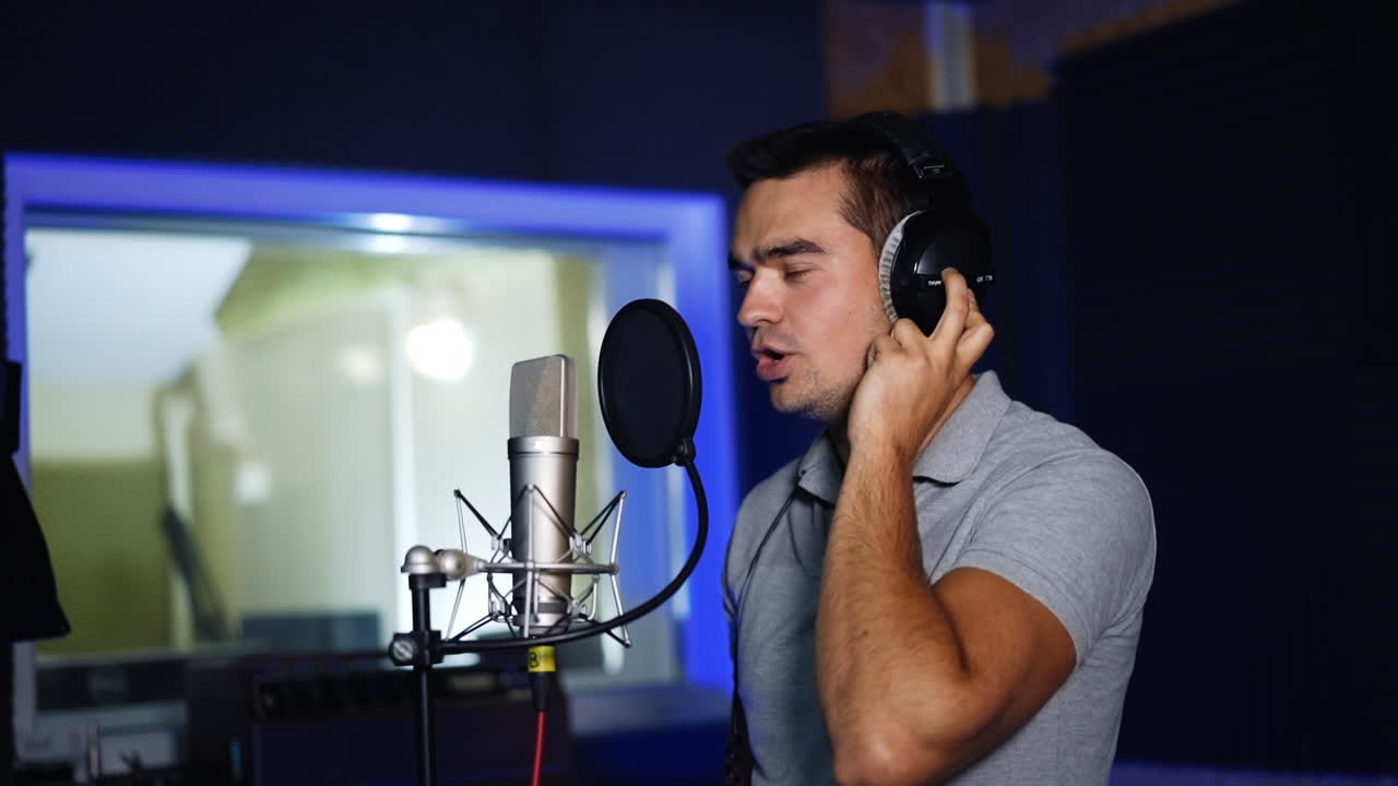 hombre cantando en el micrófono en el estudio de grabación