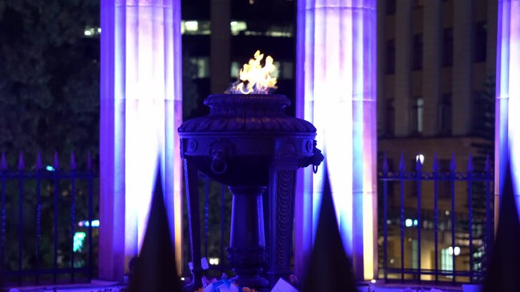 Shrine of remembrance and eternal flame burning at its heart, Anzac Square war memorial parklands at Brisbane city, Queensland, Australia, handheld motion shot