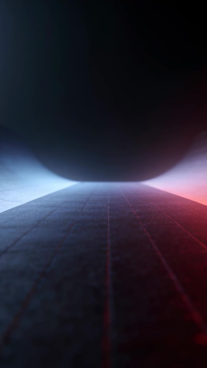 Video verticale: Telecamera che panoramica su una pista scura verso un bagliore, mostrando una tettoia, nebbia e luci blu e rosse.