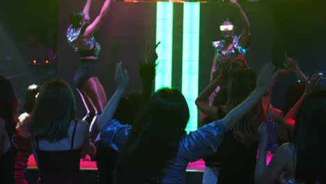 Eine-Gruppe-Von-Menschen-Tanzt-Im-Disco-Nachtclub-Zum-Takt-Der-Musik-Eines-DJs-Auf-Der-Bühne