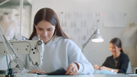 Frau-Näherin-Arbeitet-An-Einer-Nähmaschine-In-Der-Werkstatt-Zum-Nähen-Von-Kleidung.-Zusammenarbeit-In-Einer-Nähwerkstatt