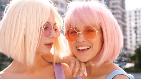 two women with pink and blonde wigs and sunglasses