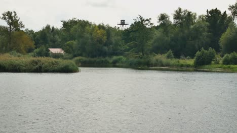 border intelligence tower among the trees on the other side of the river