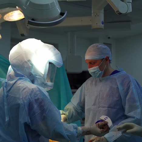 group of surgeons in the operating room. doctors in medical protective uniform performing operation in modern surgery room.