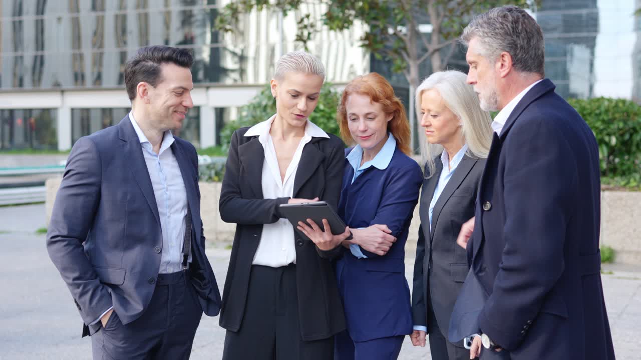 Diverse Business Professionals Collaborating on a Tablet Outdoors