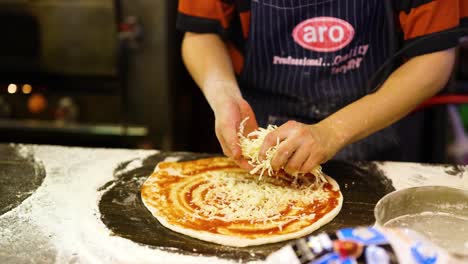 preparing pizza with cheese and tomato sauce