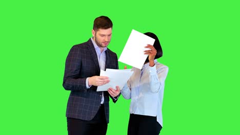 jóvenes empresarios multirraciales discuten la revisión de datos en el informe colegas leen el documento o el contrato en una pantalla verde, tecla de croma
