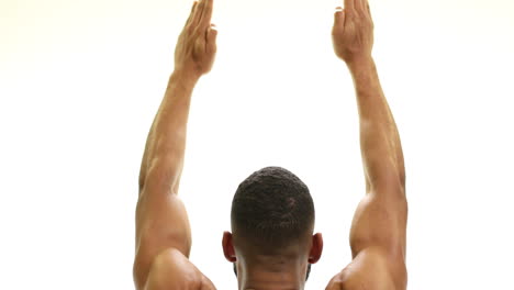 Strong-fit-athletic-African-American-man-stretching-arms-and-back-muscles-in-front-of-a-white-background