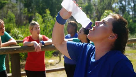 woman drinking water after workout