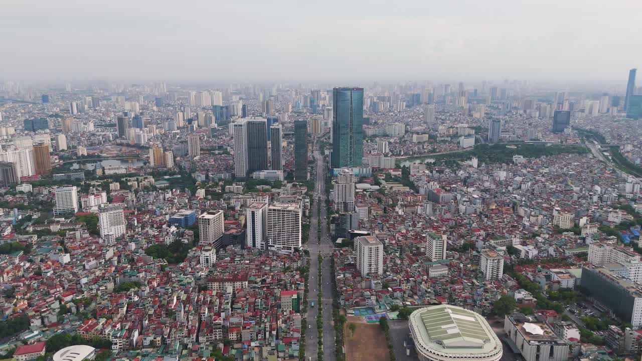 Aerial of the Hanoi cityscape during the day. The dense urban sprawl, showing a mix of traditional, low-rise buildings and modern skyscrapers. Vietnam UHD