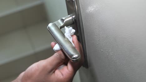 cleaning a door handle with a tissue