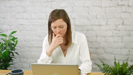 Una-Joven-Mujer-De-Negocios-Frustrada-Trabajando-En-Una-Oficina-Con-Una-Computadora-Portátil