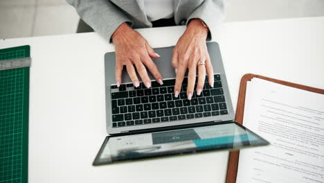 typing on a laptop at a desk
