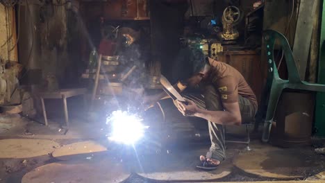 teenage welder welding at a factory workshop in dhaka, bangladesh