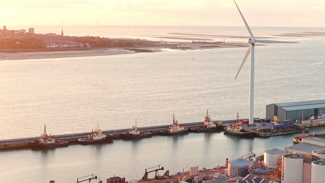 Cinematic aerial drone footage of the surrounding docks and wind turbine near Everton FC’s new Bramley-Moore Dock stadium in Liverpool, England. Captured at sunset