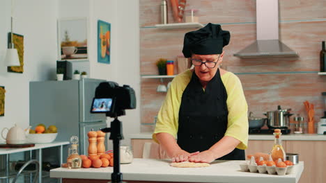 old woman recording food video in kitchen