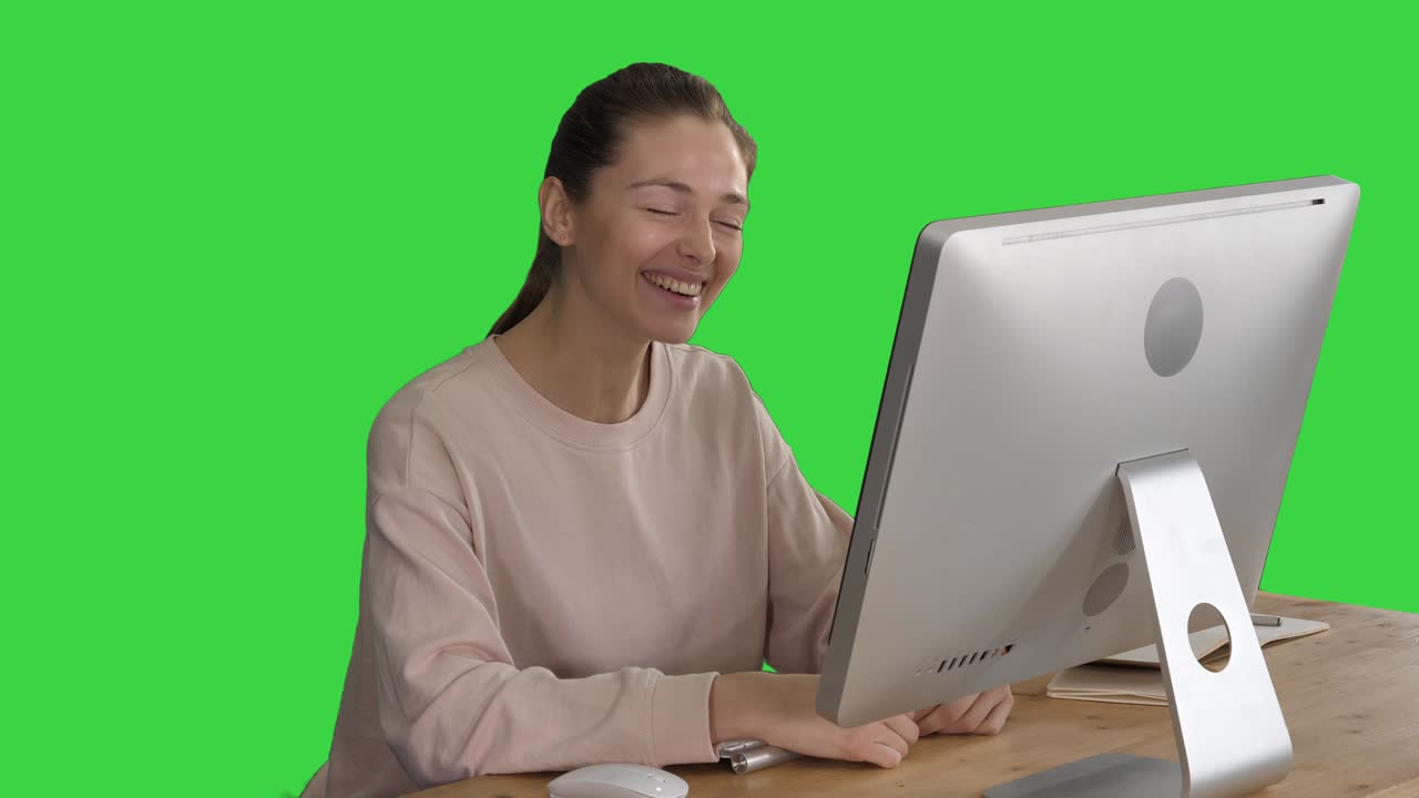 녹색 화면, 크로마 키에서 컴퓨터 앞에 앉아 비디오 통화를 하는 행복한 여성