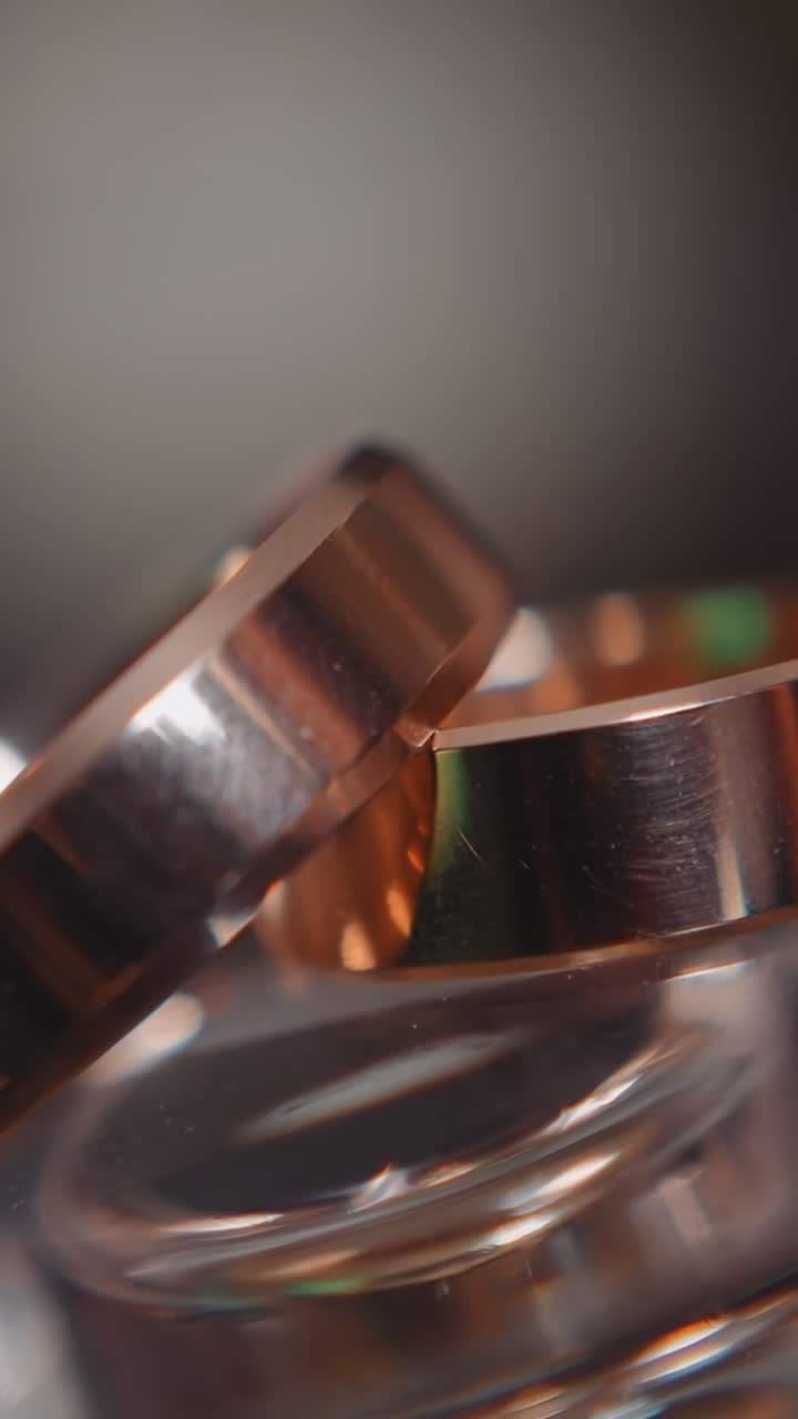 Simple style wedding rings made of gold on blurred background extreme closeup. Precious accessories for wife and husband. Bridal ceremony trends
