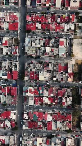 Vertical drone shot captures unique houses with red roofs in a neighborhood in Ecatepec, Mexico